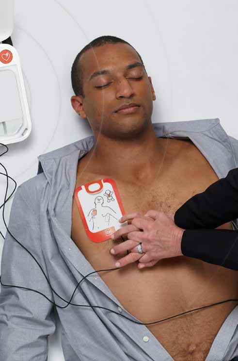 Otwórz pokrywę aparatu i odsłoń klatkę piersiową pacjenta. 2 Pociągnięcie czerwonego uchwytu i założenie elektrod.