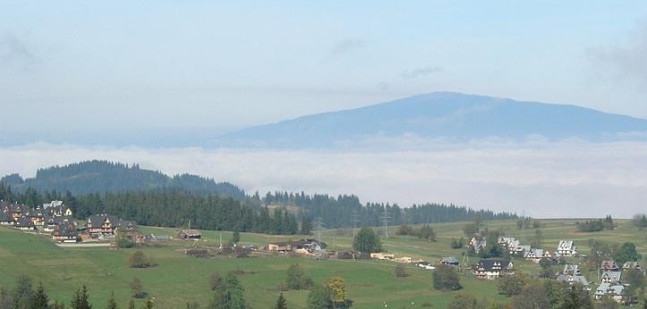 Po lewej w oddali majaczącą na horyzoncie Babia Góra (5), po prawej, z za wierzchołków drzew, górujący nad Zakopanem Giewont (6).