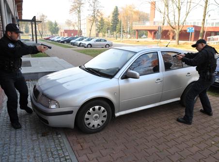 Ubezpieczający policjant przechodzi na stronę kierowcy.