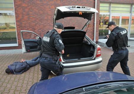 Przed podniesieniem klapy otwierający policjant daje sygnał partnerowi, aby sprawdzić jego gotowość. Fot. 20.
