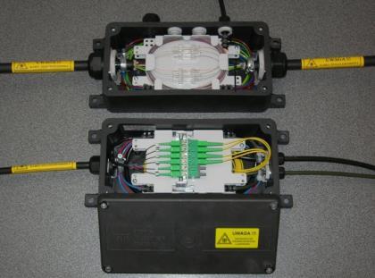 Wewnątrz skrzynki znajdują się uchwyty do mocowania kabli światłowodowych oraz dwie kasety o pojemności spojeń stałych albo jedna kaseta o pojemności spojeń i jedna kaseta ze wspornikiem złączy