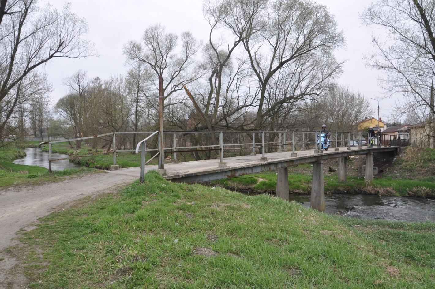 Załącznik 1 do protokołu okresowej kontroli pięcioletniej nr 4/2014 DOKUMENTACJA FOTOGRAFICZNA OBIEKTU Karta nr 1.1 Fot. 1. Widok z boku kładki dla pieszych przez rzeką Wolbórka w miejscowości Tomaszów Mazowiecki w km 1+140, w ciągu ul.