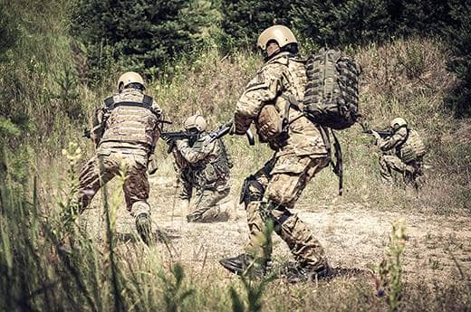 Ranny w wiosce komandos dostał postrzał w udo. Nogawkę spodni ma całą przesiąkniętą krwią. Przede wszystkim należy zatamować krwawienie, instruuje Tomasz Sanak.