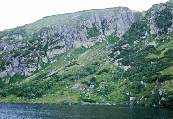 Ryc. 98. Ściany skalne Kotła Małego Stawu zostałych kotłów karkonoskich obecnością jeziora, którego misa jest wyżłobiona w twardej skale podłoża, będąc wprost rezultatem erozji lodowcowej (ryc. 96).