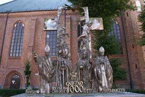 Obok historycznych postaci Bolesława Chrobrego i Ottona III pojawiły się rzeźby papieży Jana Pawła II i Benedykta XVI. Autorem zarówno pierwszego, jak i przebudowanego pomnika jest Wiktor Szostało.