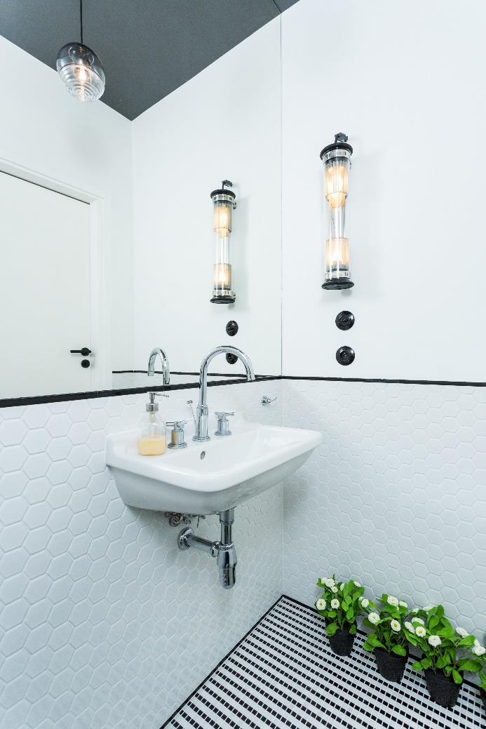 TOALETA Przestrzeń toalety, ukrytej w zabudowie kubika, jest dodatkowo powiększona dzięki lustru zajmującemu całą ścianę nad umywalką.