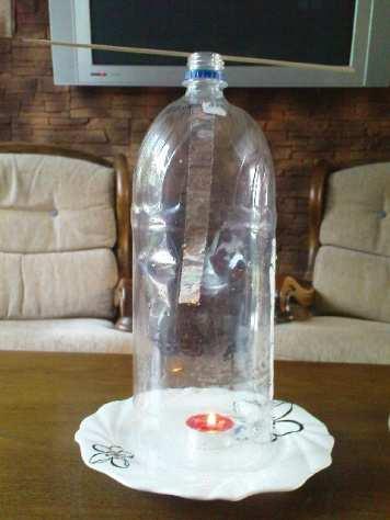 mniej gęste niż otaczające je powietrze chłodne. Chłodne powietrze nie może dostać się do świeczki dołem, ponieważ dolna krawędź butelki jest uszczelniona przez wodę.