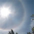 jako zjawisko halo, czyli barwne kręgi występujące wokół tarczy Słońca lub Księżyca.