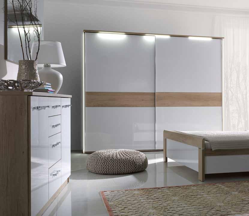 sypialnia MANHATTAN MANHATTAN Połyskowe, białe fronty i korpusy wykonane z płyty laminowanej, imitującej naturalne jasne drewno dębowe, to minimalistyczny klimat sypialni MANHATTAN.