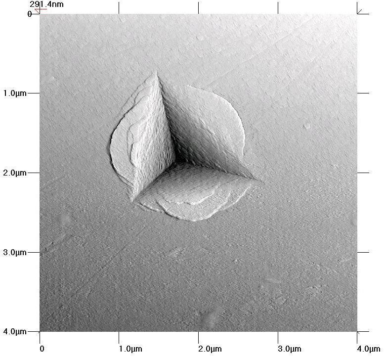 Rys. 4.31. Obraz AFM wgłębienia uzyskanego wgłębnikiem Berkovicha w metalicznym szkle Zr-Cu-Al.