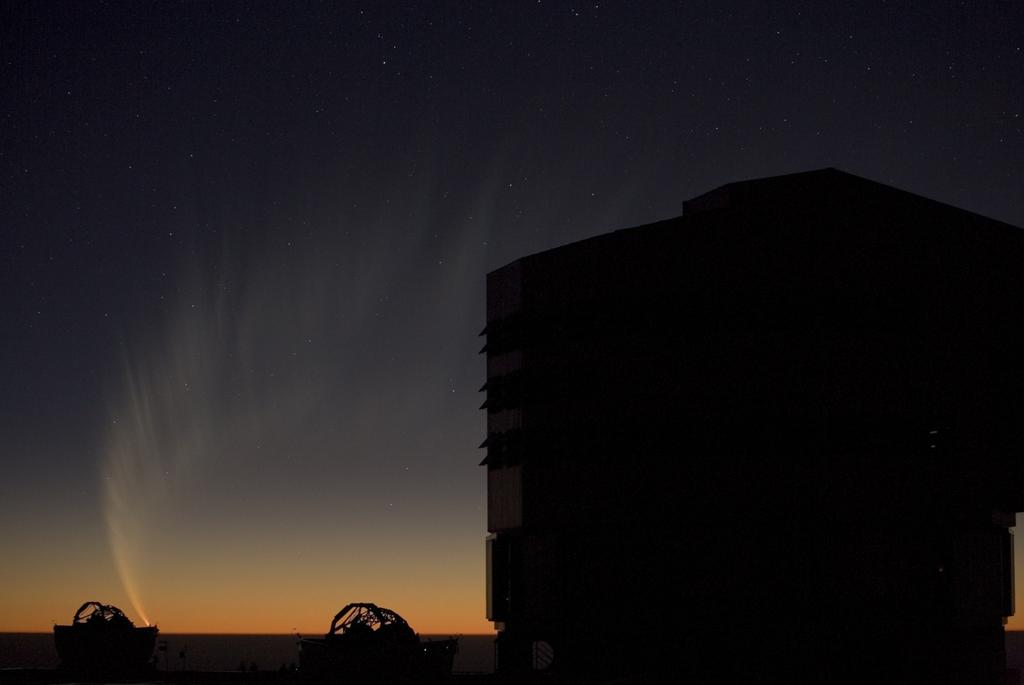 Kometa McNaught z 18 stycznia 2007 na tle VLT nad Oceanem Spokojnym. Obok dwa teleskopy pomocnicze.