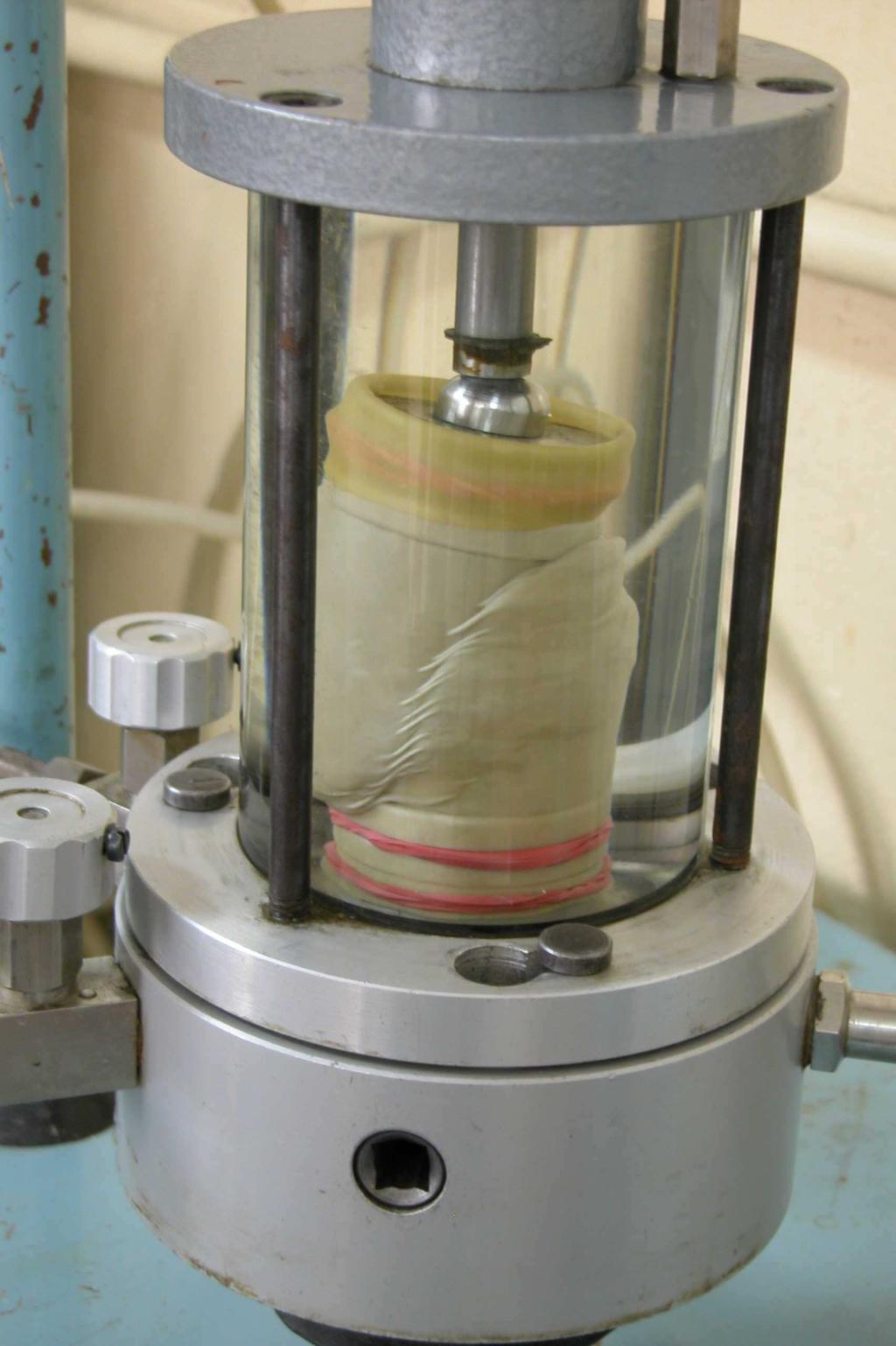 Tłok przekzujący obciążeie próbkę Komor prtu Próbk w osłoie