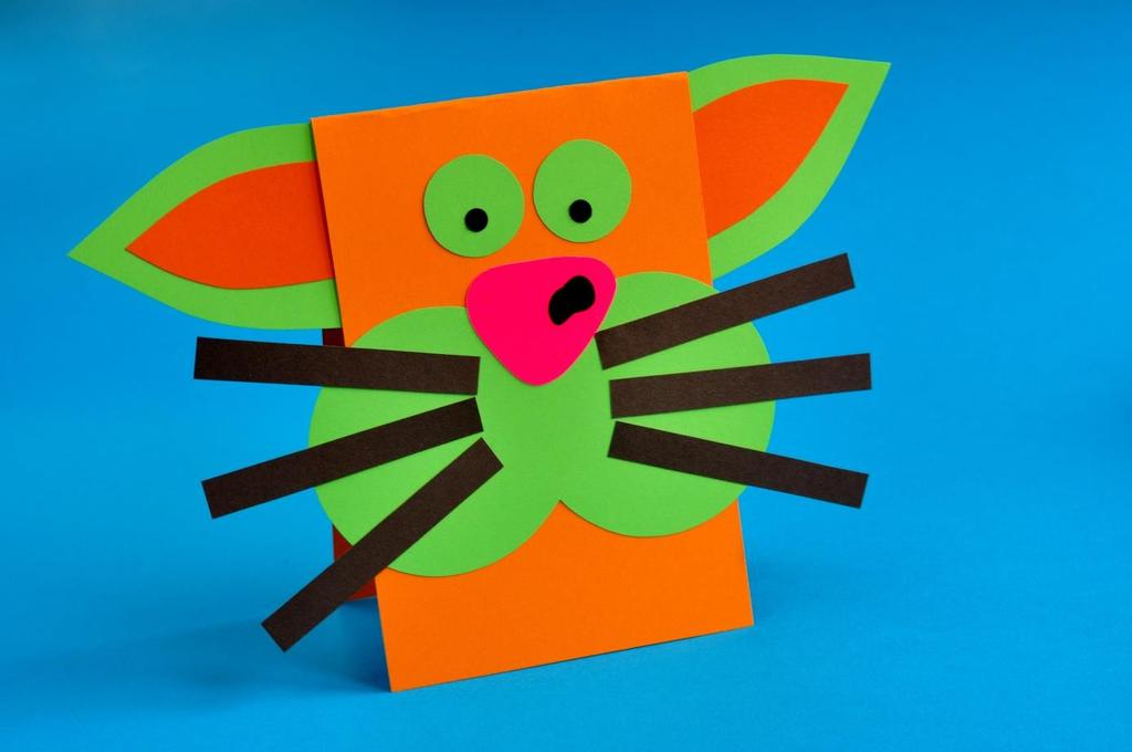 Kot Materiały: kolorowy blok techniczny, klej do papieru, nożyczki. Kartkę z bloku technicznego składamy na połowę.