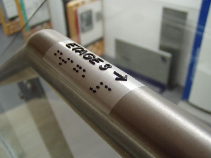 Przykład Tabliczka z informację w alfabecie Braille a i informacją wypukłą umieszczona na poręczy Źródło zdjęcia: http://www.archiexpo.fr/prod/moedel-schilderfabrikation-gmbh/product- 119551-1269695.