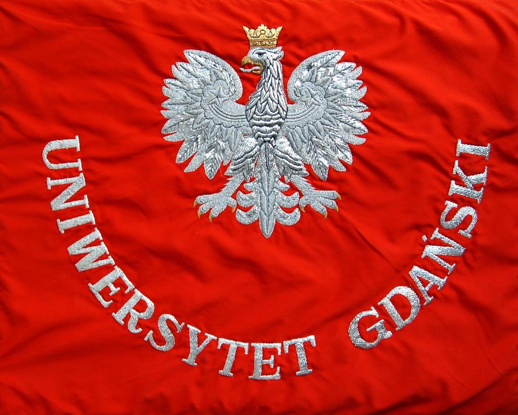 Strona prawa: tło czerwone pośrodku płata sztandaru godło państwowe haftowane srebrnym szychem i bajorkiem.