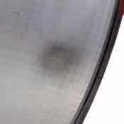 zużycia w powierzchni bieżnej Często pozostałości cząstek lub wgniecenia na stalowym grzbiecie łożyska W poważnych