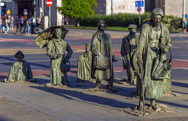 Pomysł na weekend z laską, kobietę z zakupami, mężczyzna z walizką i dziesięciu innych zwykłych przechodniów. Część postaci możemy podziwiać w całości, inne znikają w niewidzialnym przejściu.