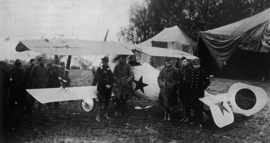 KOMENTARZE HI STO RYCZ NE Przylot Piotra Abakanowicza na lotnisko 14. eskadry wywiadowczej w Żodzinie, 1 V 1920. Stoją ppor Mańczak, Abakanowicz, ppor. Liebek, ppor. Konarski, kpt.