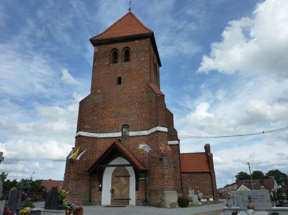 Do elewacji szczytowej przylega wieża na planie kwadratu nakryta stromym dachem namiotowym, krytym dachówką. Na osi elewacji frontowej znajduje się profilowany portal drzwiowy zamknięty łukiem ostrym.