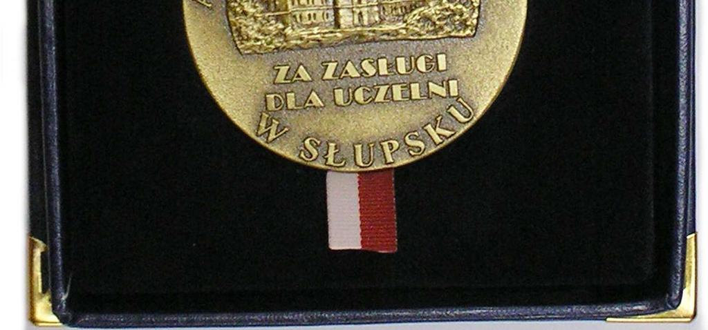 Zwyczajowo medal Za Zasługi dla Uczelni wręczany jest w etui o wymiarach 115 mm 112 mm, obłożonym aksamitem w kolorze ciemnego