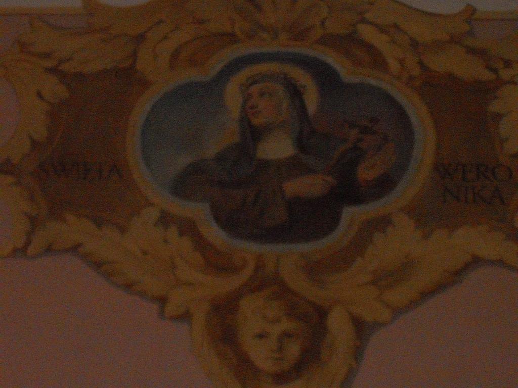 U góry na ścianie wschodniej, poczynając od strony chóru, namalowane są popiersia św. Magdaleny Martinengo (1687-1737) Kapucynki, św. Weroniki i św. Klary z Asyżu, założycielki Klarysek.