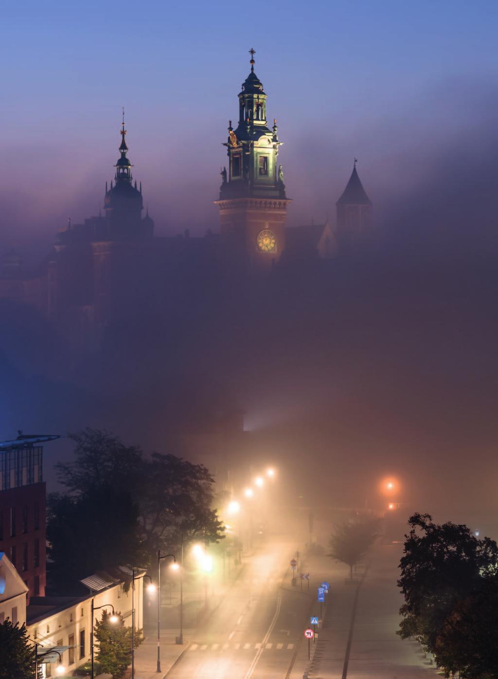 Osobliwa chmura mgły znad Wisły, która w kilka minut ukryła wawelskie wzgórze, pozostawiając widoczne jedynie trzy wieże katedry. W dole oświetlona ulica Powiśle. fot.