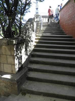 Dodatkowo schody ograniczone są murami obłożonymi płytami kamiennymi, na których znajdują się balustrady kamienne w postaci cokołów,