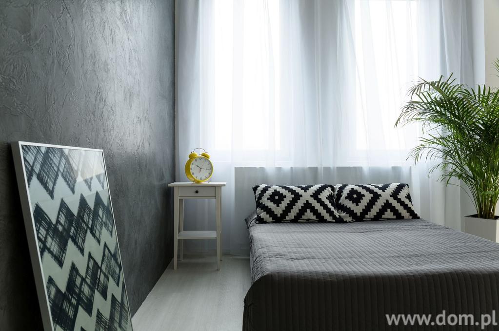 Minimalistyczna aranżacja sypialni z wykorzystaniem tynku strukturalnego.