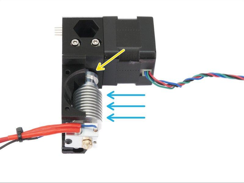 Step 21 Umieszczanie hotendu E3D Weź hotend E3D i wsuń go pod kątem w gniazdo w obudowie ekstrudera. Upewnij się, że rurka teflonowa została umieszczona prawidłowo.