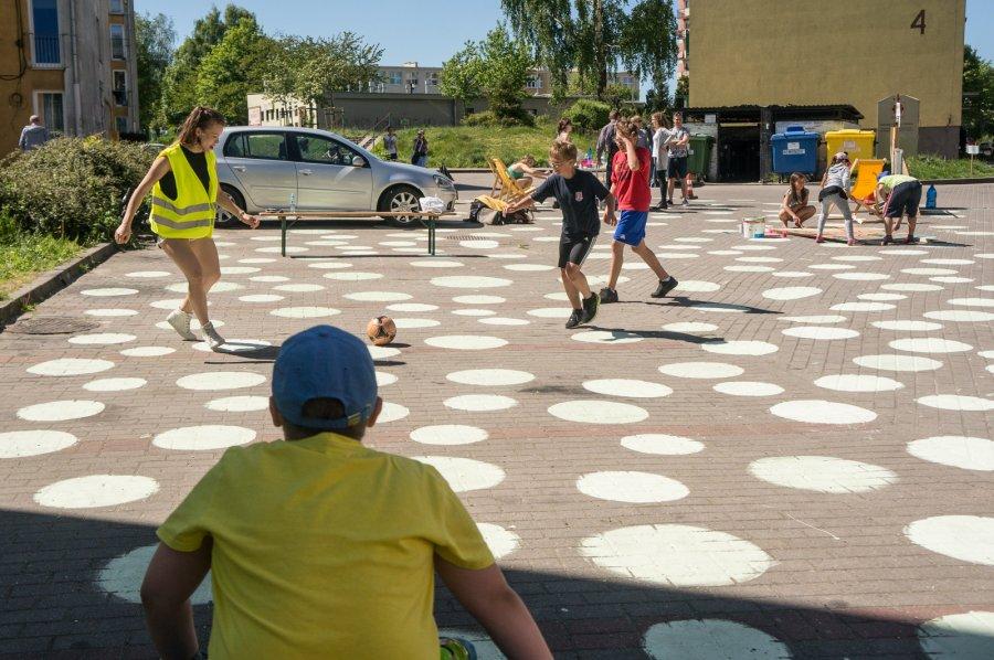 Na zapleczu budynków 4-8 przy ul. Chwarznieńskiej, na prowizorycznym boisku, nie ustawała gra w podwórkową piłkę nożną. Grają raczej młodsi - dziewczyny na równi z chłopcami.