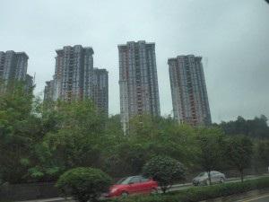 Na tle górskiego krajobrazu, w górę pną się liczne apartamentowce, a kolejne tego typu obiekty są w budowie, co uznałem za potwierdzenie ogólnokrajowego trendu związanego z migracją Chińczyków ze wsi
