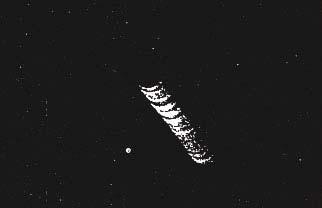 (c) Nocna fotografia cygaro-kształtnego kompleksu latającego uformowanego z kilku UFO. Wykonana ona została 20 marca 1950 roku nad Nowym Jorkiem, USA (fotograf nieujawniony, Project Blue Book).