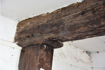 Fotografia nr 105 - Drewniana belka stropu nad parterem podparta słupem.
