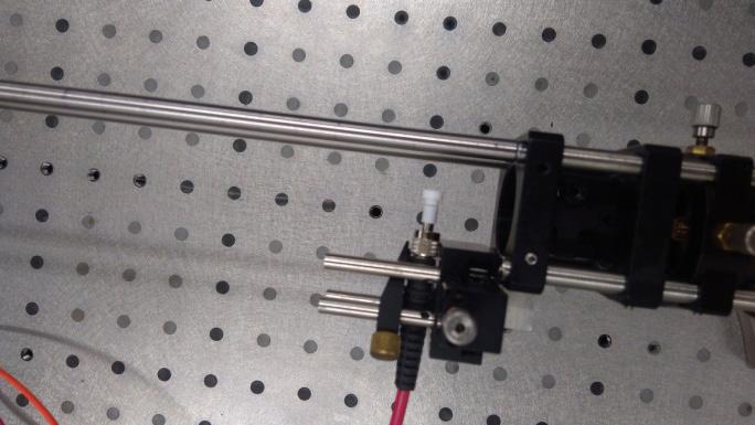 Włókna zamocowano w układzie pomiarowym, w którym wzbudzająca wiązka lasera wprowadzana była od czoła włókna, a spektrometr ustawiony był prostopadle od boku.