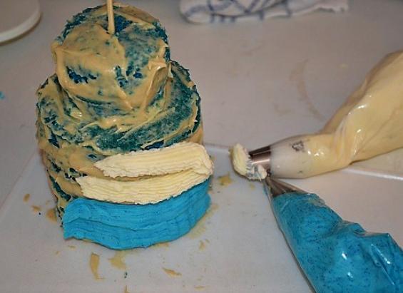 10 1/3 masy odkładamy i dodajemy do niej niebieski barwnik. Niebieska masę nakładamy na dolną część tortu, a na resztę białą.
