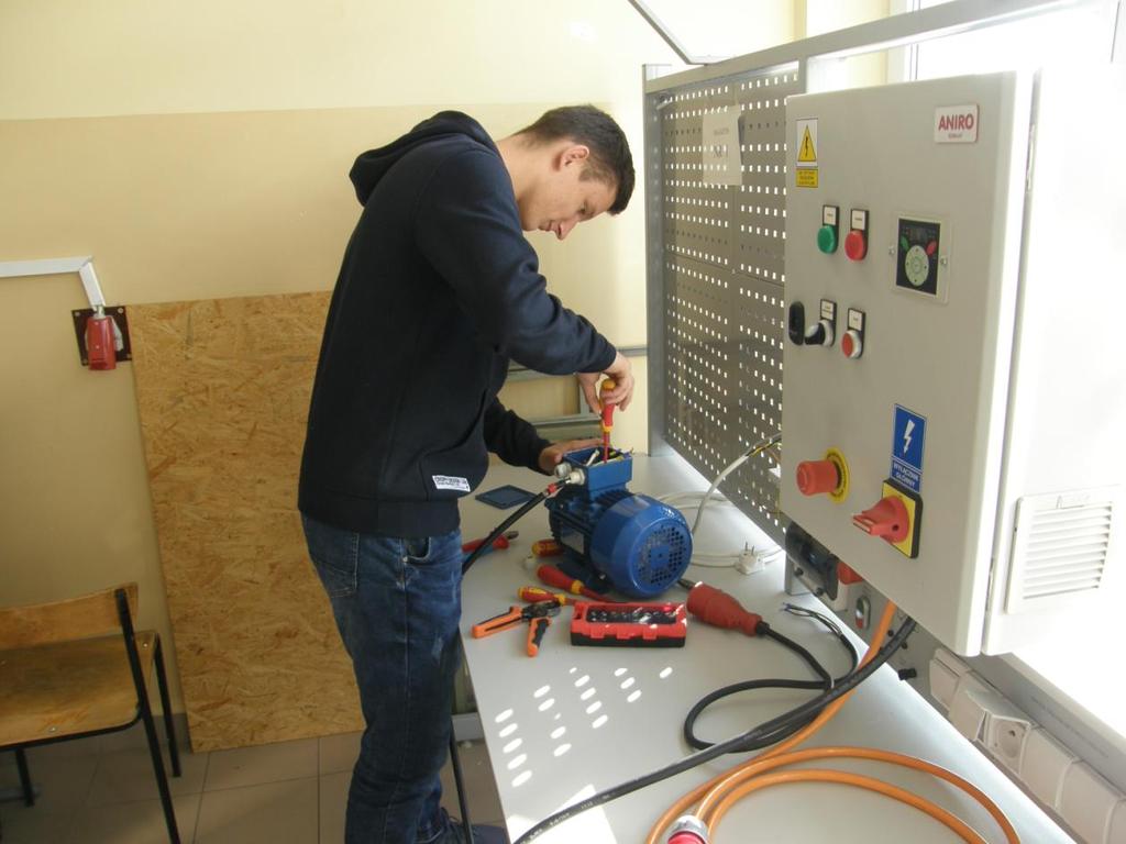 Uczeń w czasie pracowni montażu i eksploatacji maszyn oraz urządzeń elektrycznych (podłącza silnik