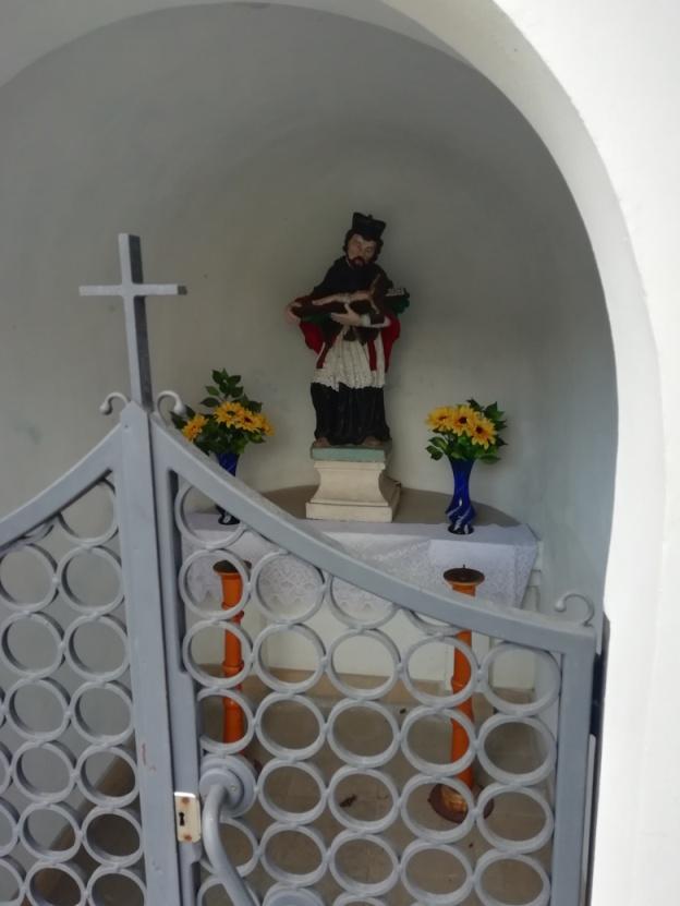 Jana Nepomucena, patrona tonących. Jest to kamienna kolorowa rzeźba nieznanego autora pochodząca z roku fundacji kapliczki.