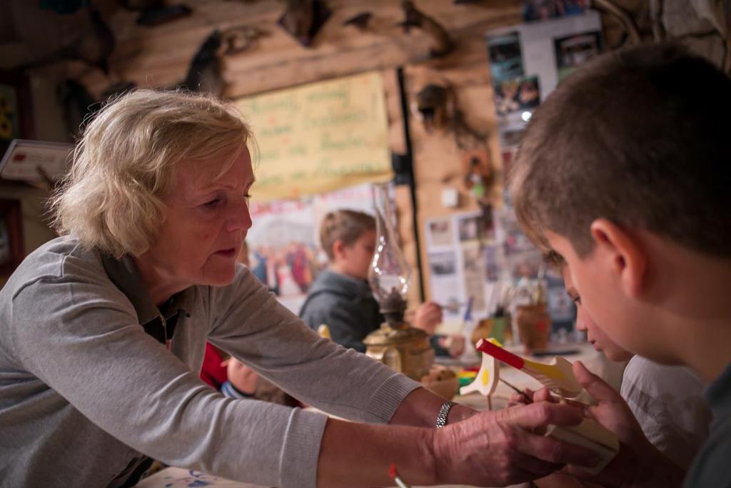 *** Dzieci wydobyły wspólnie koguta i zadowolone z rzeźby malują teraz figurki ptaków. Zabiorą je potem do domu.