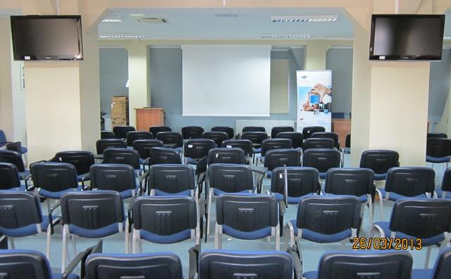 Duża sala szkoleniowa do 50 osób wyposażona jest w: - Klimatyzację; Projektor multimedialny; Ekran projekcyjny o wymiarach 200 cm x 180 cm; Dwa monitory panoramiczne o przekątnej 42 cali; Notebook z