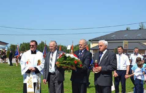 Ryszard Czepiel Radny Gminy Wadowice Górne, a zarazem Sołtys wsi Wampierzów składa wiązankę kwiatów przed pomnikiem na starym cmentarzu. Po prawej stronie fotografii ks.