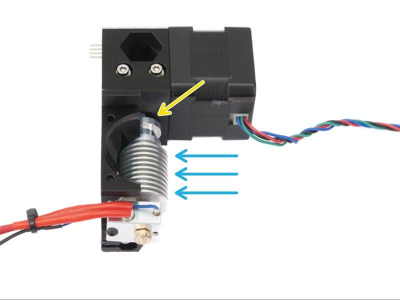 Step 20 Umieszczanie hotendu E3D Weź hotend E3D i wsuń go pod kątem w gniazdo w obudowie ekstrudera. Upewnij się, że rurka teflonowa została umieszczona prawidłowo.