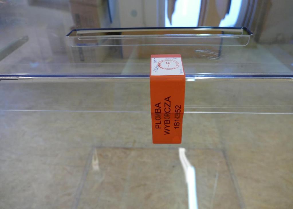 ZADANIA OKW W DNIU GŁOSOWANIA - przed otwarciem lokalu wyborczego 43 Zabezpieczenie urny przed nieuprawnionym otwarciem za pomocą plomby naklejkowej Na plombę naklejkową należy nakleić dostarczoną