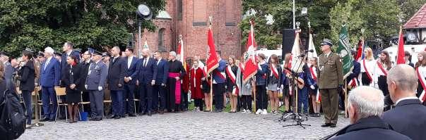 5 Po nabożeństwie zajmujemy miejsca na Skwerze Sybiraków Poczty Sztandarowe, Orkiestra Policji i Kompania Honorowa zajmują miejsce k/pomnika Zesłańcom Sybiru Flaga na Maszt