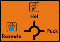 kierunek zmiany trasy. Zmiana kierunku szlaku rowerowego. Strzałka wskazuje Drogowskaz tablicowy szlaku rowerowego.
