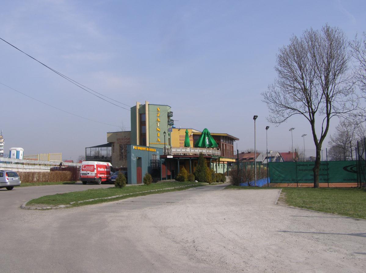 Widok obiektu przewidzianego do rozbiórki. Konstrukcję wsporczą tarasu i ogrodu zimowego stanowią słupy stalowe w postaci rur okrągłych.