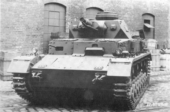 Czołg PzKpfw. IV Ausf. E na dziedzińcu fabrycznym. ponieważ zmniejszył się nacisk jednostkowy na grunt. Zmiana ga sienic wymusiła modyfikację kół napędowych i napinaja cych.