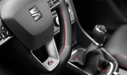WNĘTRZE - KIEROWNICE Reference Comfort+ Style Comfort+ FR Techno+ Sportowa kierownica wielofunkcyjna z logo FR i dźwignia hamulca ręcznego obszyte skórą z czerwonymi przeszyciami s Sportowa