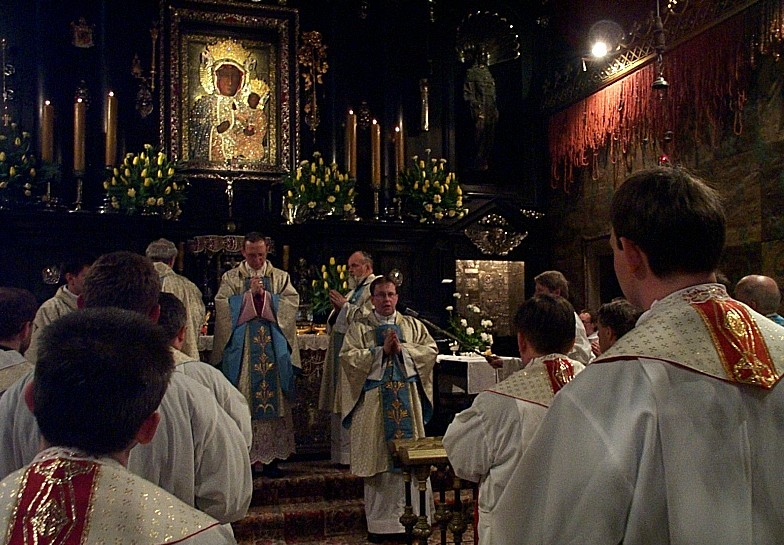 Procesja z darami GC w asyście diakonów przyjmuje dary stojąc przed ołtarzem OŁ i C pomagają odebrać dary kwiaty