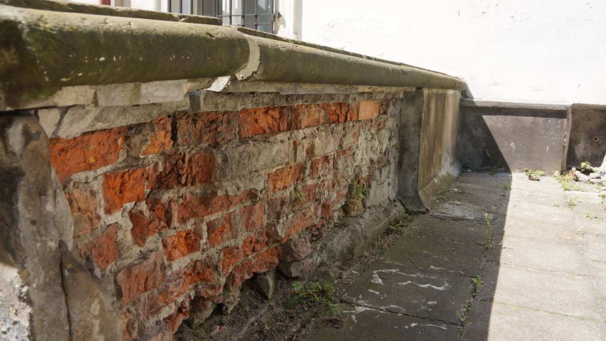 Skutkiem zasolenia jest destrukcja tynku, a następnie samych cegieł, z których zbudowany jest mur.