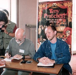 Terry Pratchett sk³ada autografy. Obok zerka podejrzliwie Arek Nakoniecznik. gorii powieœci Marek S. Huberath za Drug¹ podobiznê w alabastrze.